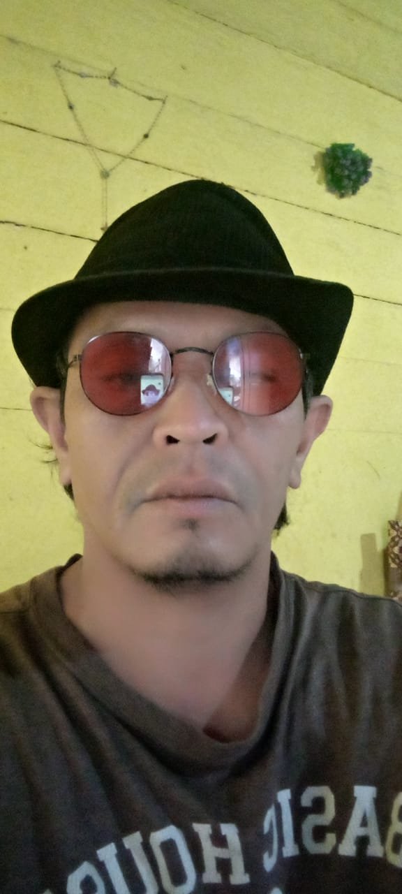 Darwin Sitanggang di depan rumah adat Sipukka Huta Lumban Silo Samosir